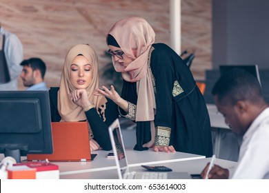 Two Woman With Hijab Working On Laptop In Office.