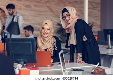 Two Woman With Hijab Working On Laptop In Office.