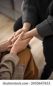 Two woman holding hands to each other concept of support care trust help sisterhood top view closeup. Female arms touch togetherness partnership friendship mental healing psychology therapy melancholy