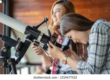 Two Woman Looking Through Binoculars Or Telescope