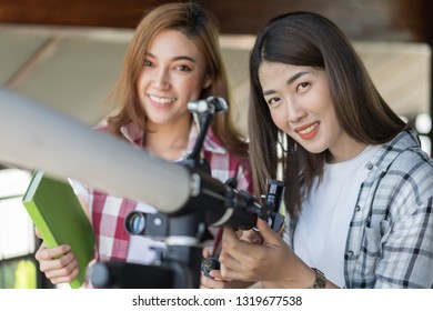 Two Woman Looking Through Binoculars Or Telescope