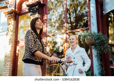 Two Woman In Small Town Downtown America Laughing.