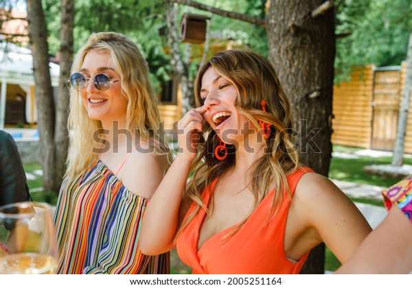 two\
woman smile while standing outdoor in sunny summer day rubbing nose\
while talk and smile friendship and leisure\
concept