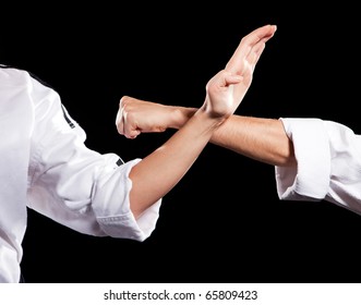 Two womans fighting hands in white kimono on black background - Powered by Shutterstock