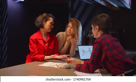 Two women argue with tattoo master at the expense of sketches - Shutterstock ID 1740981704