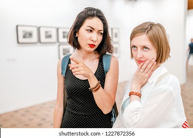 Two Women Art Critics Discuss A Picture Or Photo In The Art Gallery