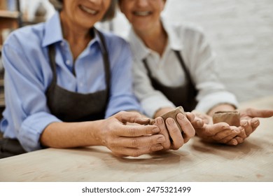 Two women in an art studio working with clay. - Powered by Shutterstock