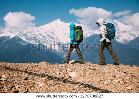 Two women backpackers hiking  in beautiful winter high altitude mountains