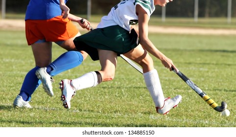 Two Women Battle For Control Of Ball During Field Hockey Game