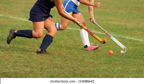 Two Women Battle For Control Of Ball During Field Hockey Game 