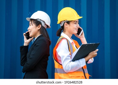 Two Women Business And Factory Worker Using Smartphone And Talking. Worker People Communicate By Technology Phone To Manage Work Process. Portrait Woman Standing On Blue Background Wall.