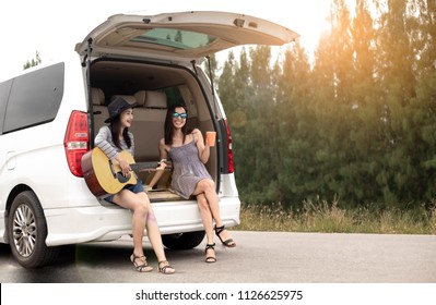 Two Women In The Car Playing The Guitar For Relaxing . Travel In The Holidays.