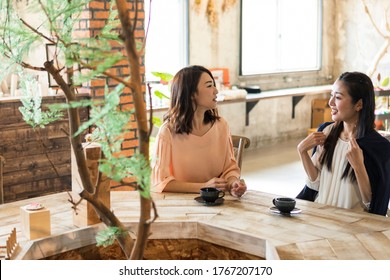 Two Women Chatting At A Cafe