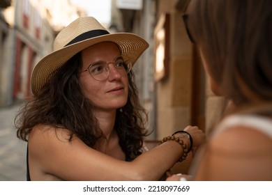 Two Women Chatting And Laughing Outside A Bar In Spain