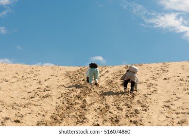 Two women climbing sand dune in Tottori, Japan - Powered by Shutterstock