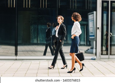 Two women commuting to the office in the day carrying office bags. Ceo and her assistant walking on a city street. - Powered by Shutterstock