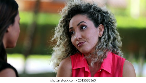 Two Women In Conversation Outside At Park. Friends Female Talk