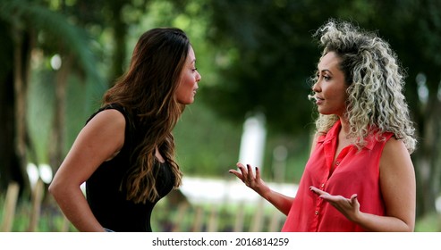 Two Women In Conversation Outside At Park. Friends Female Talk