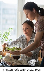 Two Women Cooking Pizza At Home. Filling Pizza With Ingredients