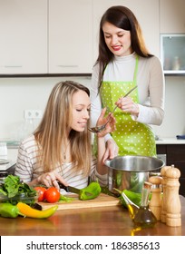 Two   Women Cooking Something Together At Them Kitchen