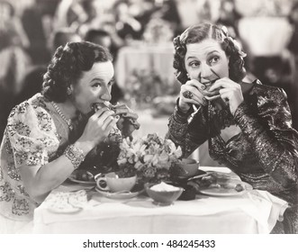 Two women distracted from their meal