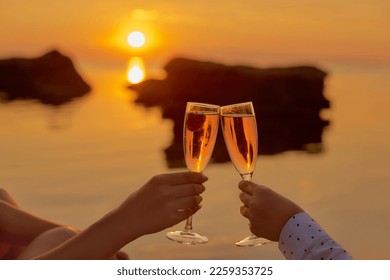 two women drinking champagne with strawberries on the beach. romantic breakfast sunrise together - Powered by Shutterstock