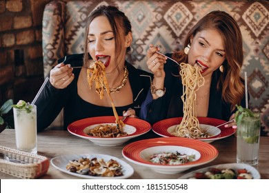 Two Women Eating Pasta In An Italian Restaurant