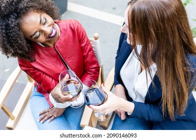 Two Women Flirting And Drinking Wine In A Restaurant, Top View Of Female Friends Toasting With Red Wine 