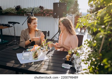 Two Women Friends Eating Fresh Oysters And Drinking Chilled Prosecco Wine On The Summer Sunset In Restaurant. Seafood Delicacies