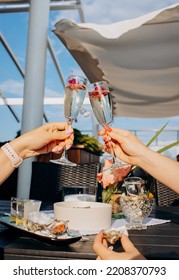 Two Women Friends Eating Fresh Oysters And Drinking Chilled Prosecco Wine On The Summer Sunset In Restaurant. Seafood Delicacies