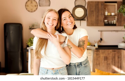 Two women friends hugging at home. Adorable lesbian couple. Best friends, affectionate and happy.