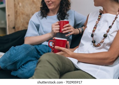 Two Women Friends Talking To Each Other On A Couch In Apartment