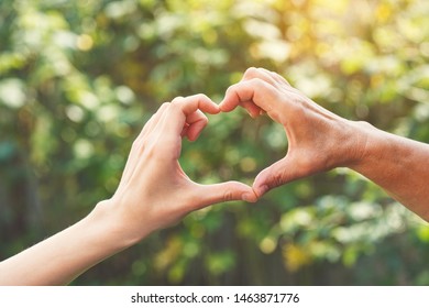 Two Women Generations, Family Relationship, Senior People Care, Family, Love, Close Up Young Female Hand And  Wrinkled Hand Of Senior Woman Making Heart Shape