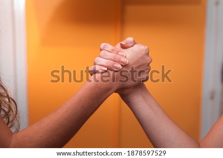 Two women greeting clashing their hands