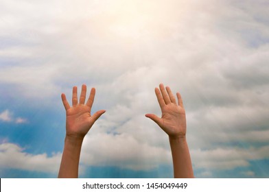 two women hands reach for the sunlight against the blue sky with clouds