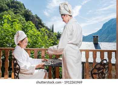 Two Women Having Coffee And Breakfast On A Balcony With Mountain Views