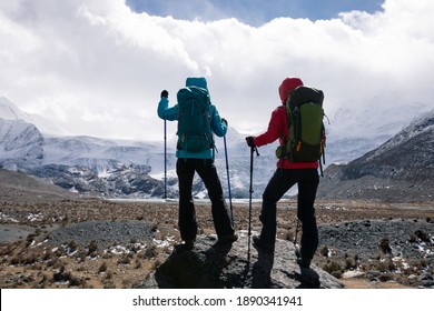 Two Women Hikers Hiking In Winter High Altitude Mountains