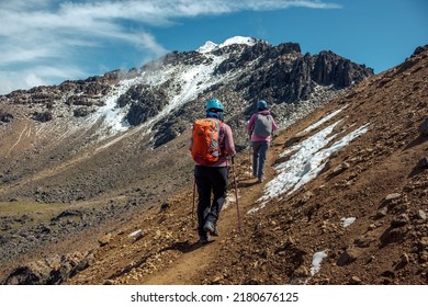 Two Women Hiking Up A Mountain