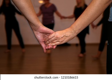 Two Women Holding Hands During A Women's Dance Circle 