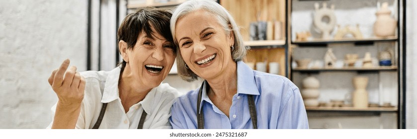 Two women, likely a couple, laugh together in a pottery studio, surrounded by their creations. - Powered by Shutterstock