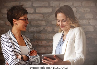 Two Women Looking On Ipad And Talk About Business Indoor 