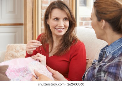 Two Women Making Quilt At Home Together