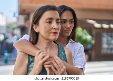 Two Women Mother And Daughter Hugging Each Other With Relaxed Expression At Street