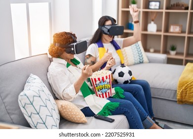 Two Women Mother And Daughter Watching Soccer Match Using Vr Glasses At Home