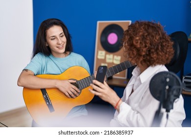 Two Women Musicians Having Classical Guitar Lesson By Smartphone Video At Music Studio