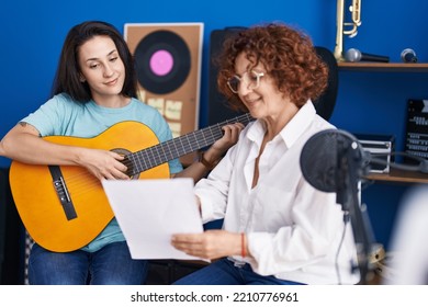 Two Women Musicians Having Classical Guitar Lesson At Music Studio