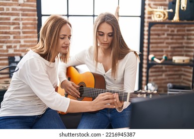 Two Women Musicians Having Classical Guitar Lesson At Music Studio