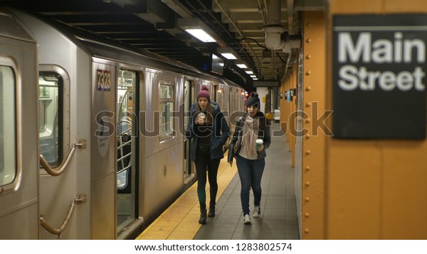 Two women on a\
platform of a New York subway station wait for their train - NEW\
YORK / USA - DECEMBER 4,\
2018