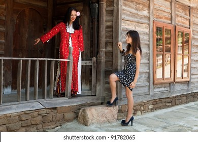 Two Women, One Modern And One In Traditional Bulgarian Costume, Greeting Eachother