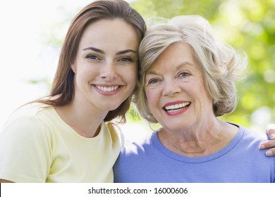 Two women outdoors embracing and smiling